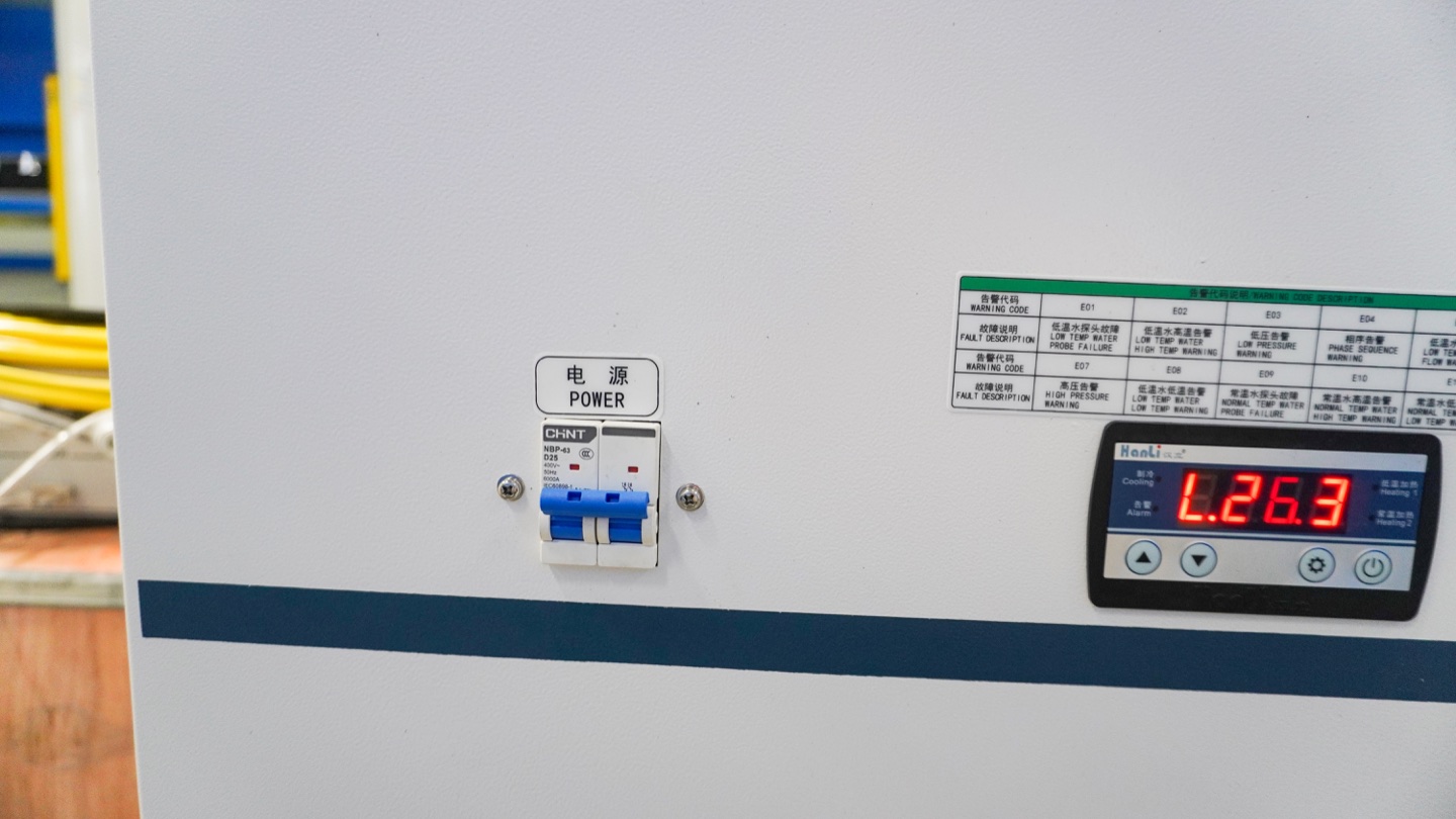 Chiller power switch, temperature display and alarm reference label for routine cooling-system checks.
