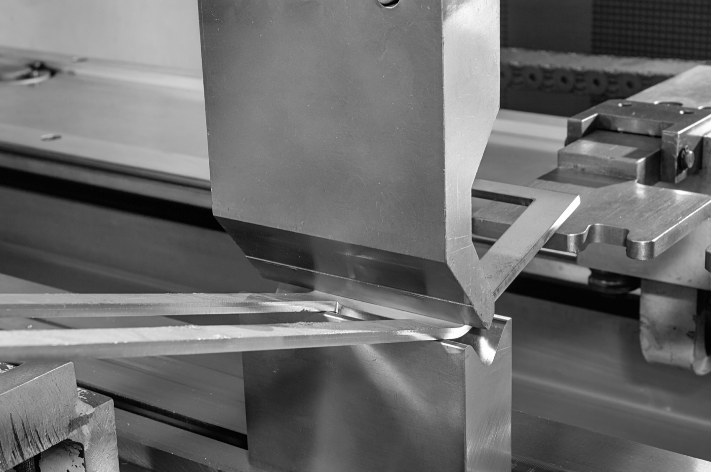 Close-up of sheet metal forming between press brake tools